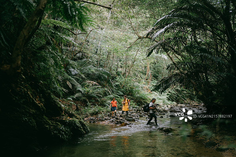 一家人在日本冲绳的丛林河流中徒步旅行图片素材