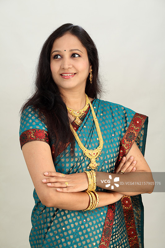 白色背景前交叉双臂的年轻印度传统女性图片素材