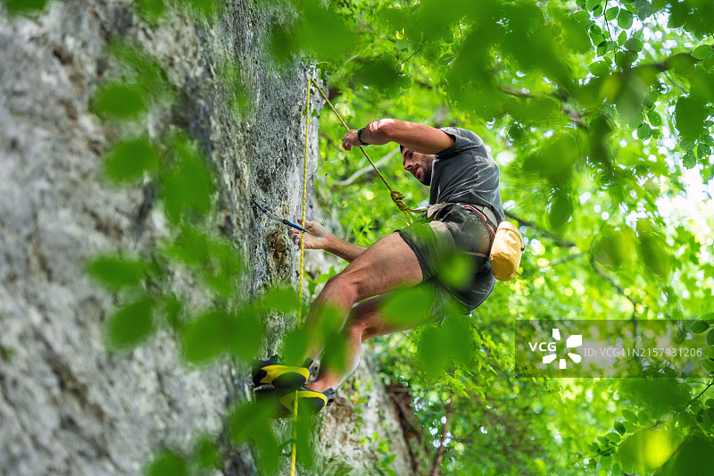 身穿运动装攀登悬崖的白人男子图片素材