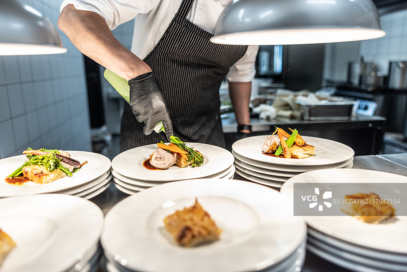 厨师在将食物送到餐厅客人面前，装饰商业厨房的食物图片素材