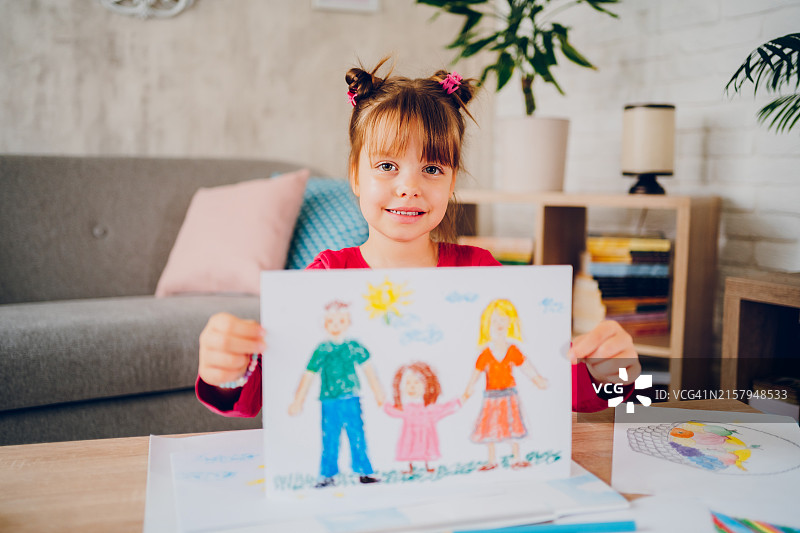 可爱小女孩展示她的家庭绘画图片素材