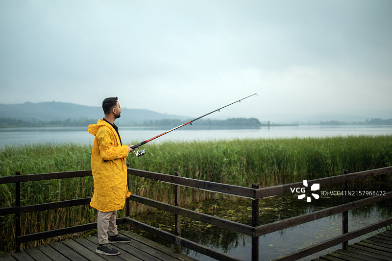 男人用鱼竿钓鱼，淡水鱼，淡水钓鱼，休闲活动和爱好图片素材