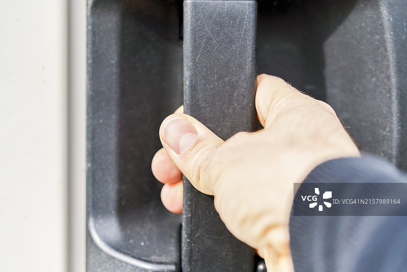 特写：拉动金属门把手的人的手图片素材