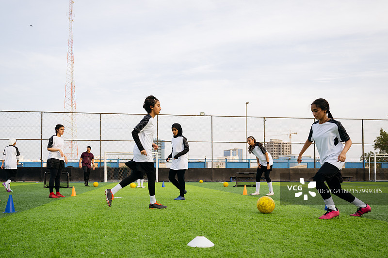 沙特青少年在足球训练中跑步和运球图片素材
