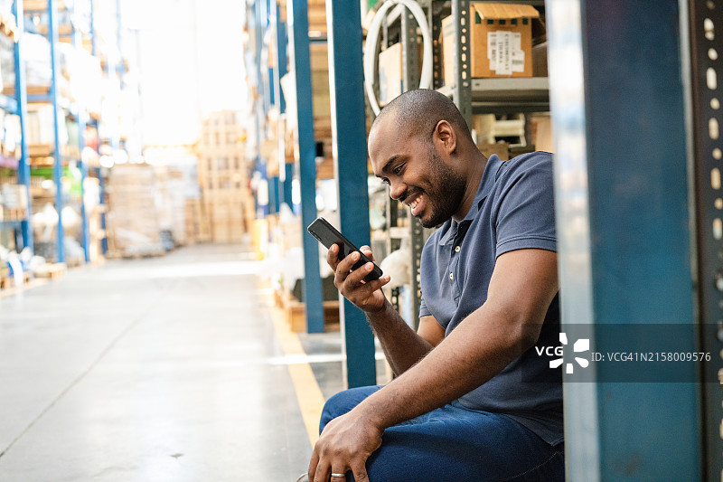 非洲仓库工人休息时使用手机图片素材