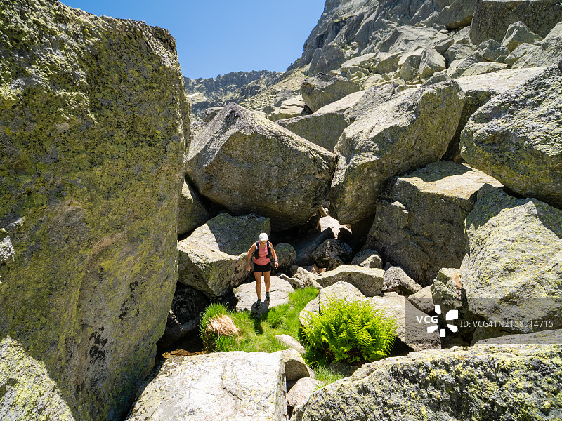 在极端地形的山脉中徒步的女人图片素材