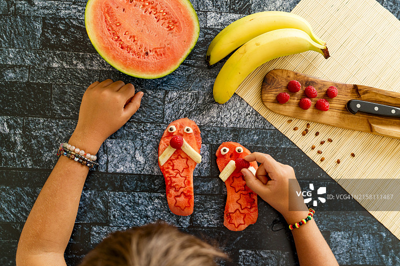 开心的男孩用水果制作物品图片素材