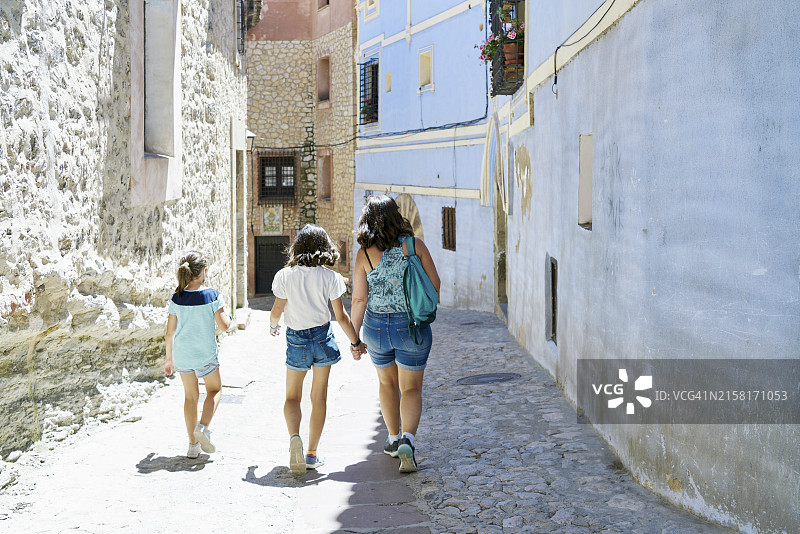一家人在西班牙狭窄的街道上行走图片素材
