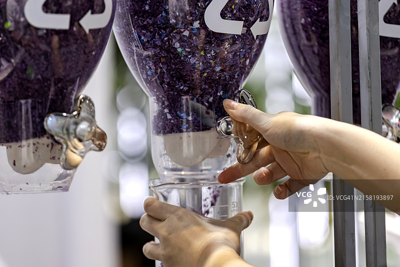 女性在回收塑料中拿着塑料薄片图片素材