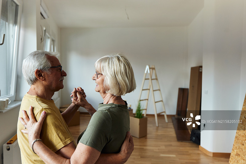 快乐的年长夫妇在新公寓里跳舞图片素材
