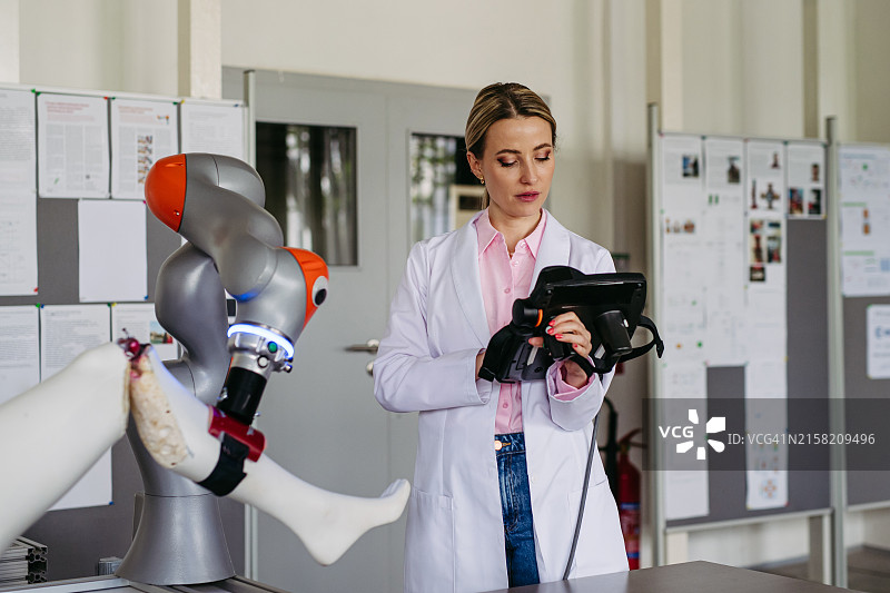 从事机器人膝关节置换手术项目的女性机器人工程师，医疗保健中的机器人、工程和计算机科学概念图片素材