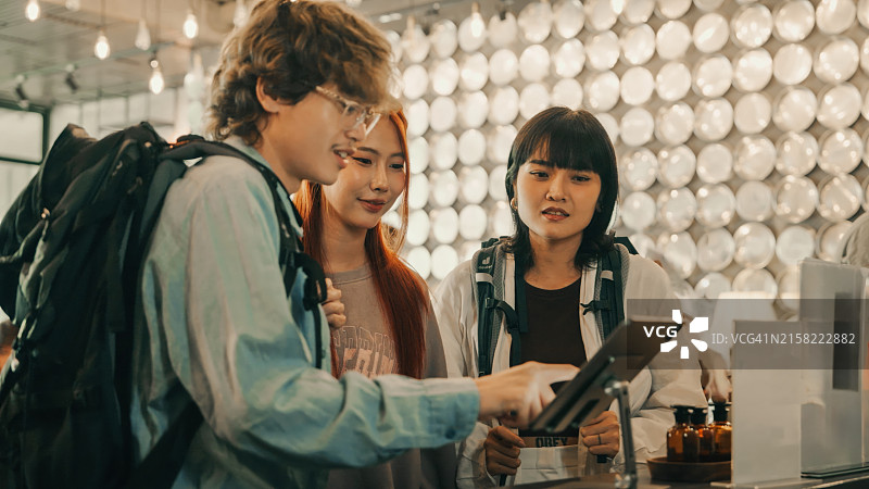 朋友在旅馆的平板电脑上使用自助入住图片素材