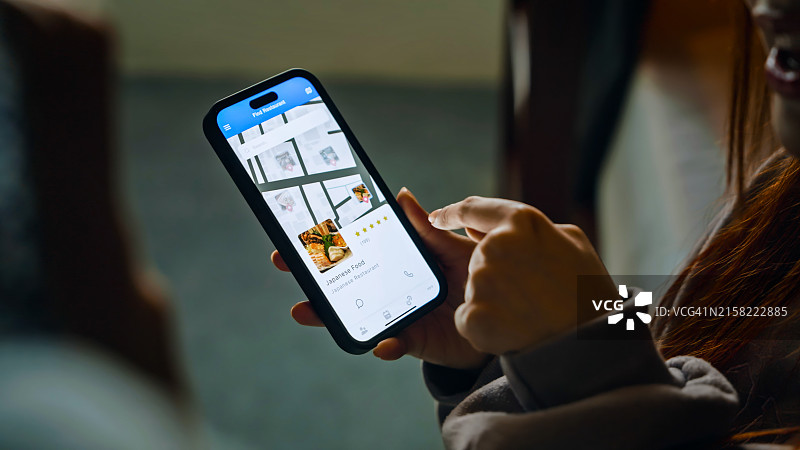 一群人使用智能手机上的地图App查找餐厅的特写图片素材