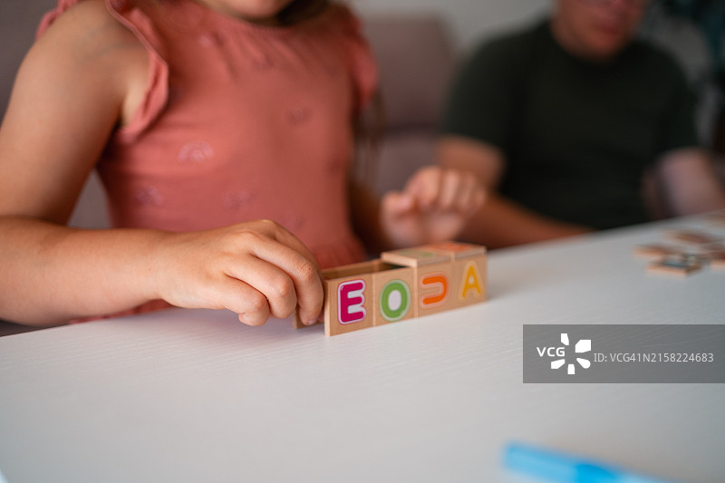 孩子在家用木制字母积木玩耍的特写图片素材