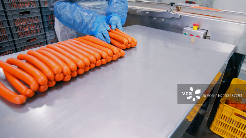 工人在生产线上处理香肠图片素材