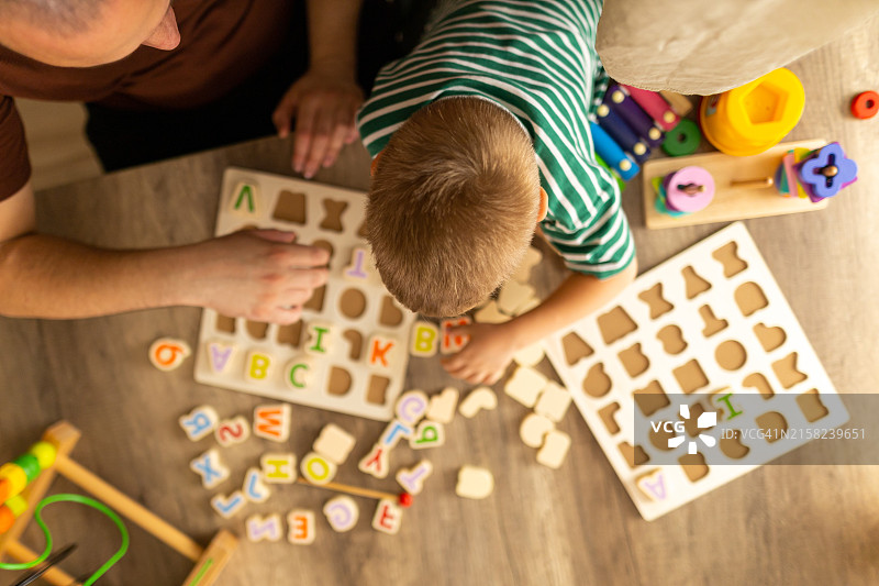 父亲和幼儿玩字母游戏，亲密互动图片素材