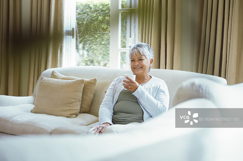 年长的女人在客厅喝咖啡图片素材
