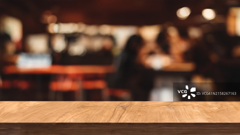 咖啡店模糊背景前的木板空桌，可用于产品展示或装配图片素材