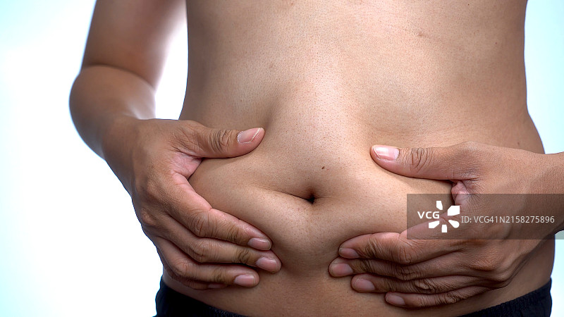 捏肚子上的脂肪特写图片素材