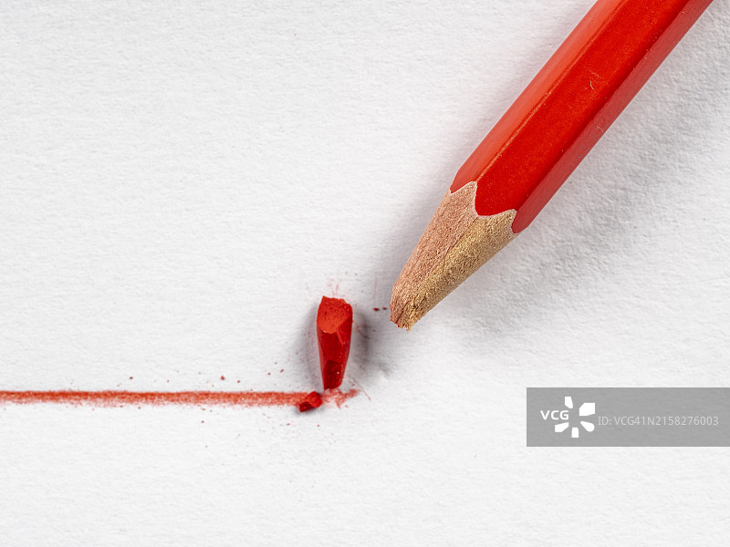红铅笔在纸上画直线图片素材