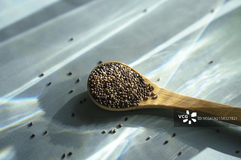 蓝色背景上的一勺奇亚籽图片素材