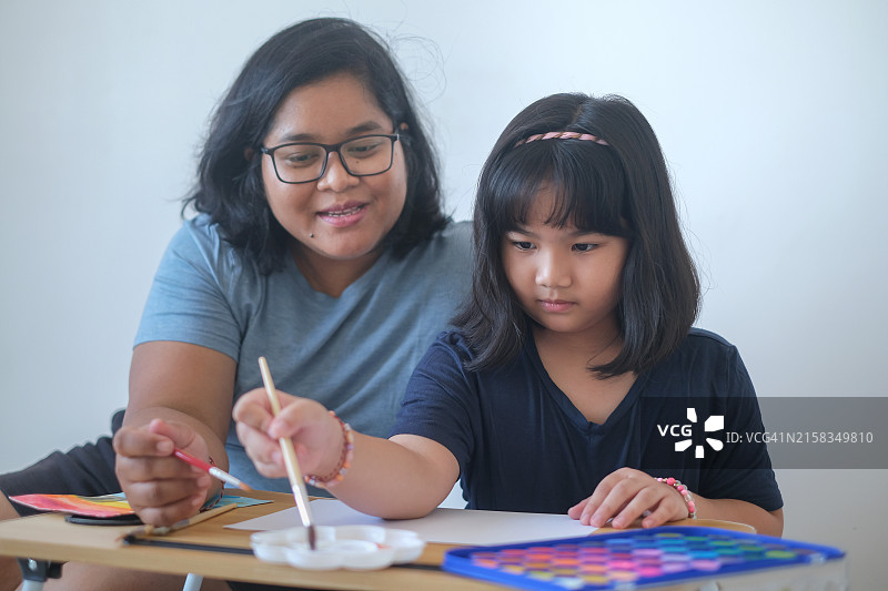 印度尼西亚小女孩在美术课上绘画图片素材