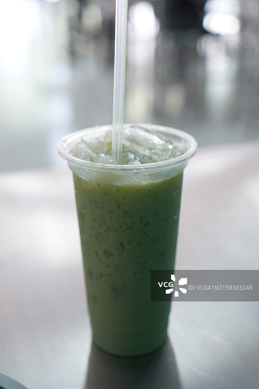 冰镇绿茶，不锈钢桌上盛有冰块的冷萃茶饮特写图片素材
