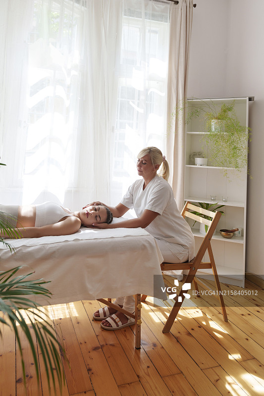 骨科医生坐在椅子上，在诊所治疗患有颈部疼痛的青少年患者图片素材