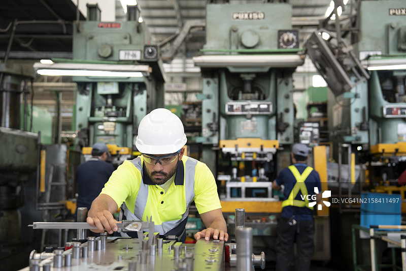 男质检工程师在制造工厂检查产品尺寸图片素材