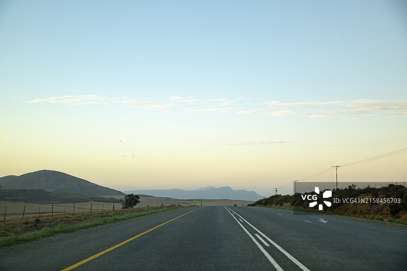 日落时分天空下的空旷道路图片素材