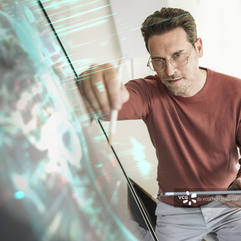 男子使用数位笔在平板电脑上书写图片素材