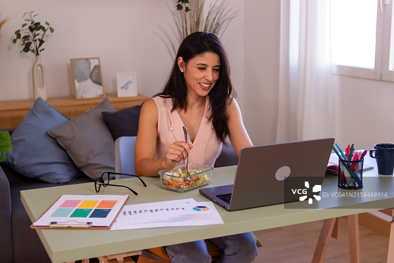 在家办公吃沙拉的拉丁裔女商人图片素材