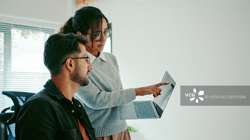 在现代办公室审查笔记本电脑代码的西班牙裔程序员图片素材