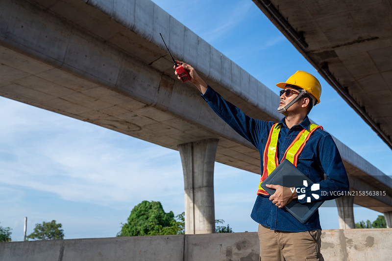 亚洲年轻的土木工程师在道路施工现场检查道路结构工程。监督新道路建设。在高速公路建设中的土木工程师。图片素材