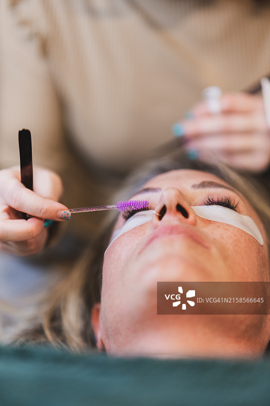 美容过程：手持睫毛工具靠近顾客面部图片素材