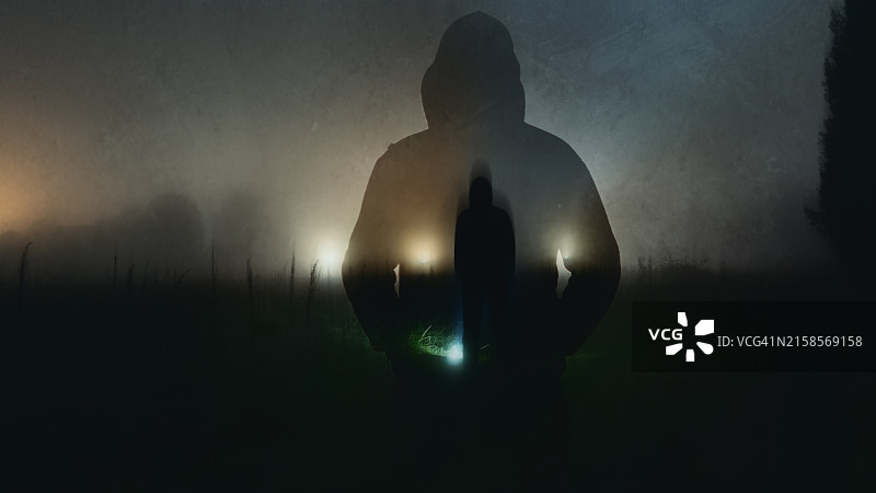 神秘的蒙面人在乡村一个怪异的雾夜背景中的双重曝光，带有抽象的编辑图片素材