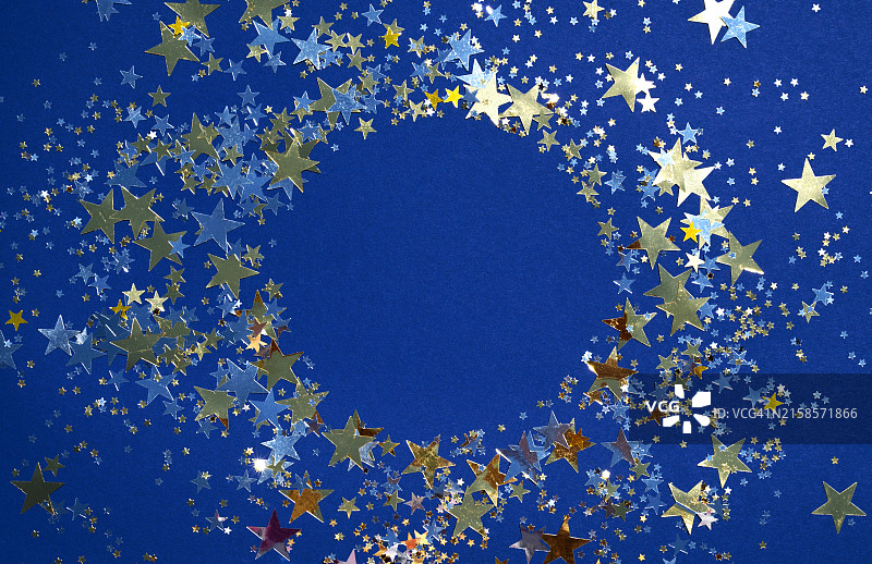 圆形框架中的蓝色节日背景，带有金色五彩纸屑星星的文本位置图片素材