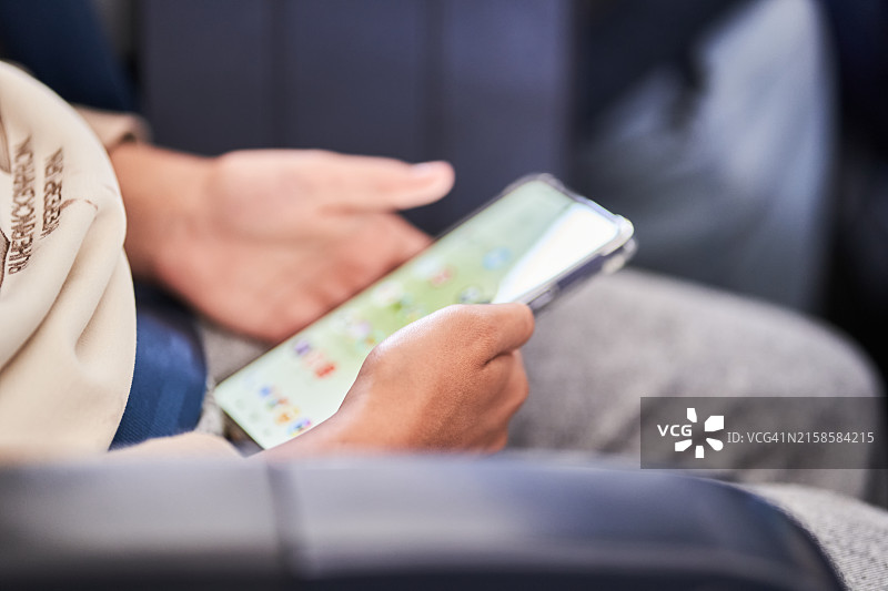女孩在飞机上使用智能手机，特写镜头图片素材