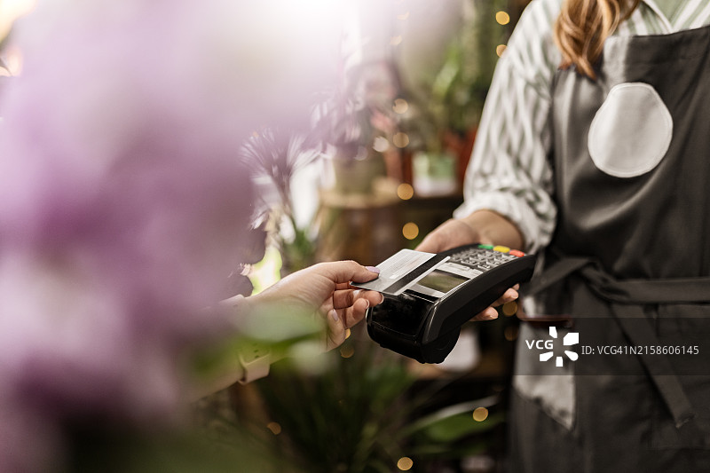 年轻女子用信用卡支付一束鲜花图片素材