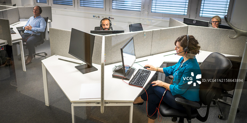 现代隔间工作区中的多元化办公室员工图片素材