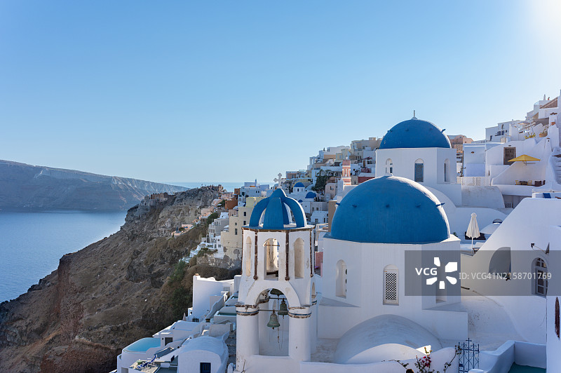 希腊基克拉泽斯群岛圣托里尼岛伊亚，城市景观，房屋和带钟的教堂，背景是海图片素材