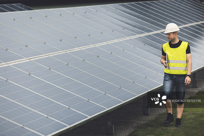 在户外检查太阳能电池板的技术员图片素材