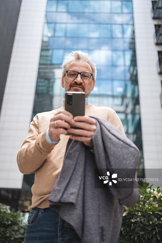 现代商务人士在城市环境中用手机小憩图片素材