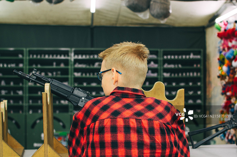 男孩在射击场用枪射击图片素材