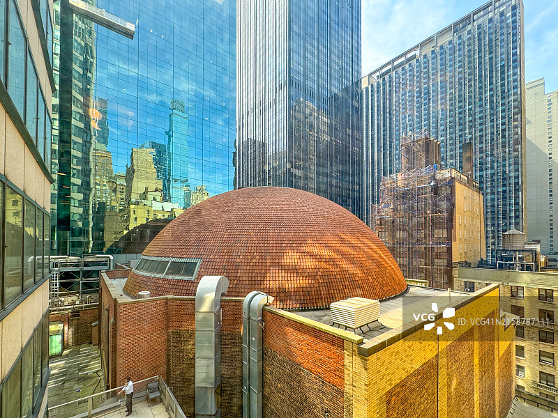 在纽约市建筑屋顶上打电话的男人图片素材