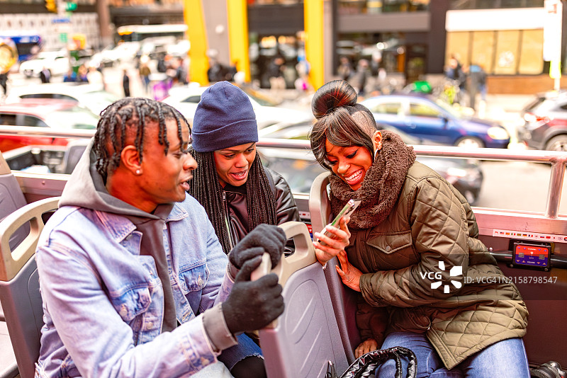 朋友们在白天乘坐巴士游览城市图片素材