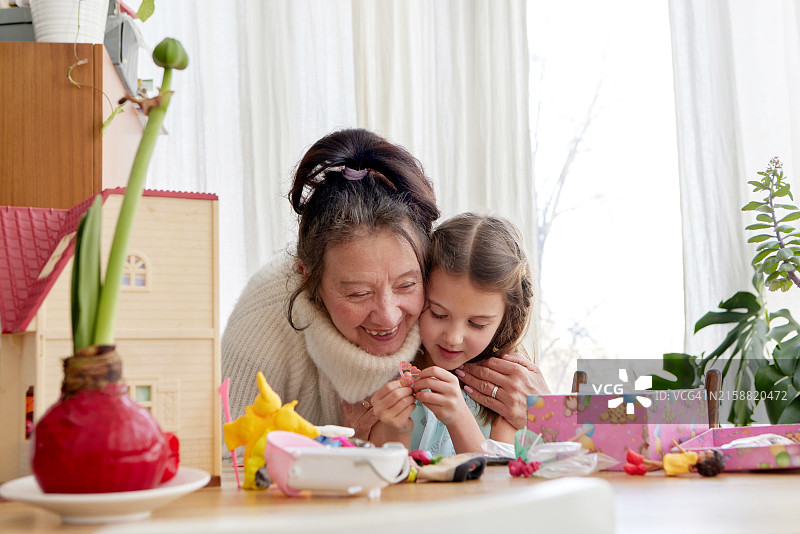 快乐的奶奶与孙女聊天，坐在桌子旁图片素材
