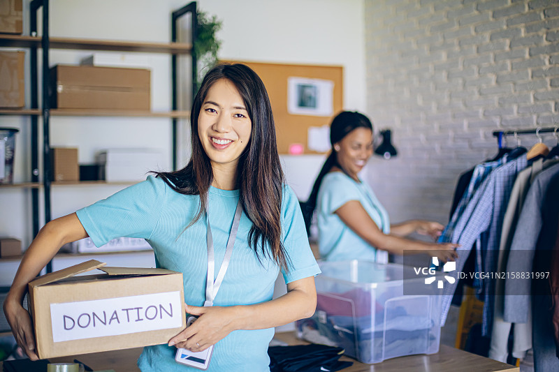 手持捐款箱的年轻亚洲女志愿者肖像图片素材