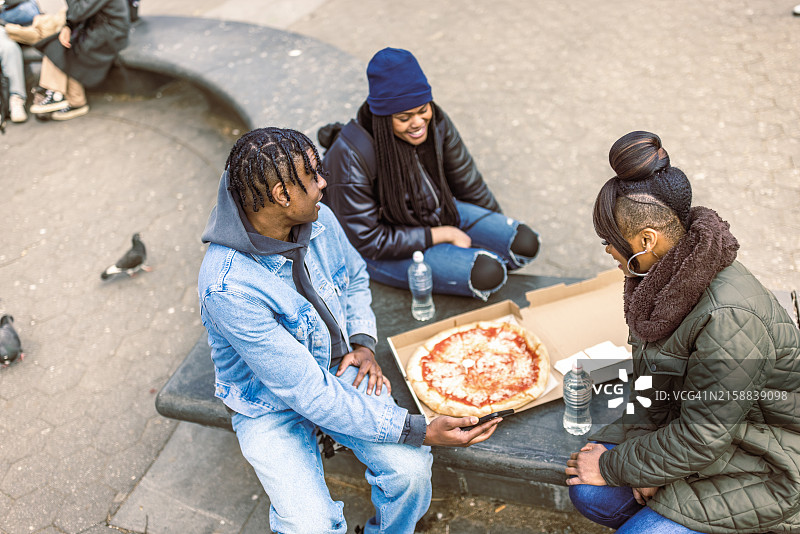 朋友们在华盛顿广场公园享用披萨图片素材