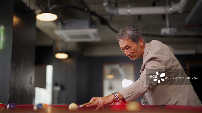 在办公室打台球的年长商人图片素材